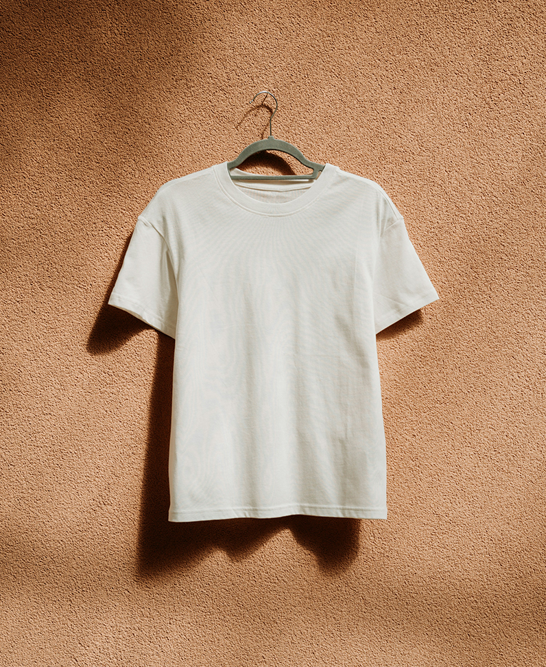 Fotografie: weißes T-Shirt, dass an einer Wand hängt